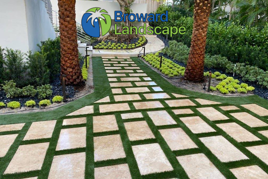 Modern garden path with square stone tiles and green grass.
